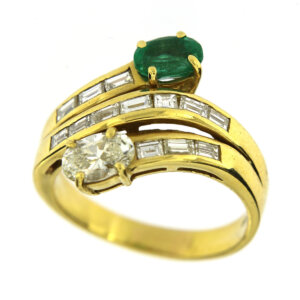 Anello in oro giallo 18 kt contrarie con uno smeraldo ovale da circa 0.55 ct, un diamante ovale da circa 0.60 ct colore IJ purezza VS e 13 diamanti taglio baguette da 0.06 ct cad, tot 0.78 ct