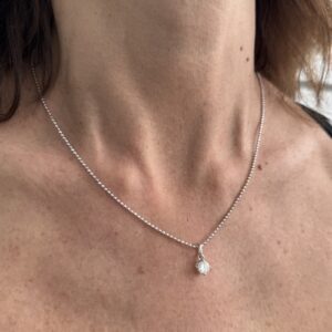 Foto gioiello indossata: collana punto luce con diamante in oro bianco con maglia pallini