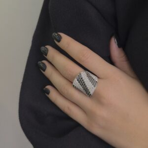 Foto gioiello indossata: anello a fascia in oro bianco con diamanti trasparenti e diamanti neri pavè