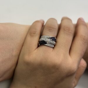 Foto gioiello indossata: anello a fascia in oro bianco con diamanti e zaffiri pavé