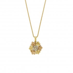 Collana in oro giallo 18 kt maglia a spiga con ciondolo rotondo composto da 7 fiori: 3 in oro giallo, 3 in oro rosa satinati ed un fiore centrale in oro bianco satinato.