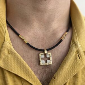 Foto gioiello indossata: collana in caucciù due ori Baraka con ciondolo croce