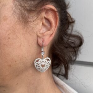 Foto gioiello indossata. orecchini pendenti in oro bianco con cuore e diamanti