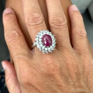 Foto gioiello indossata: anello platino halo a forma di fiore con rubino centrale e diamanti