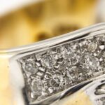 zoom dettaglio di anello oro bianco e oro giallo con diamanti
