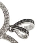 zoom dettaglio diamanti neri su ciondolo in oro bianco a forma di cuore con diamanti