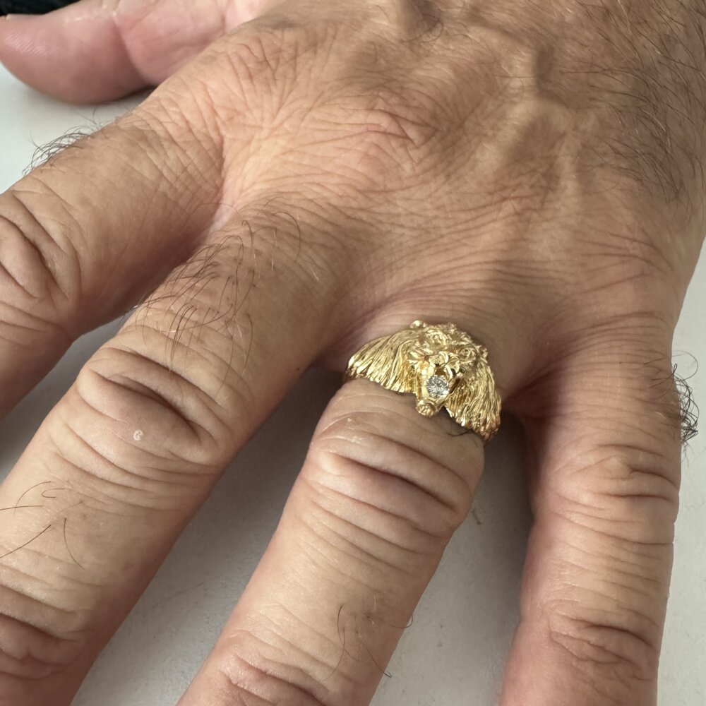 Foto gioiello indossata: anello con testa di leone in oro giallo e diamantino