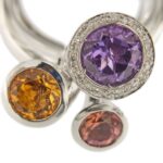zoom dettaglio pietre preziose: ametista, quarzo citrino e granato su anello oro bianco con diamanti e testa amovibile