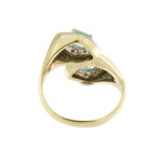 Visione retro di anello contrarie oro giallo con smeraldo e diamanti