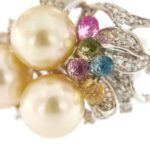 zoom dettaglio perle e pietre preziose su orecchini in oro bianco con diamanti
