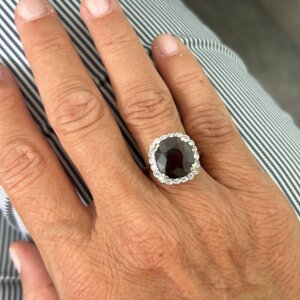 Foto gioiello indossata: anello in oro bianco con granato e diamanti a forma di fiore