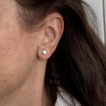 Foto gioiello indossata: orecchini punto luce con diamante modello cipollina in oro giallo