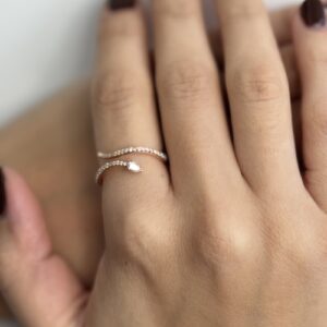 Foto gioiello indossata: anello in oro rosa contrarié a forma di serpente con diamanti
