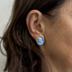 Foto gioiello indossata: orecchini in oro giallo a lobo con chiusura a clip con cammeo azzurro raffigurante un volto di donna