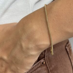 Foto gioiello indossata: bracciale maglia pallini in oro giallo
