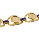 dettaglio di bracciale vintage oro giallo con monete e smalto