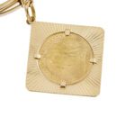 dettaglio zoom di ciondolo sterlina su bracciale oro giallo bangle rigidi