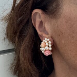 Foto gioiello indossata: orecchini a lobo con perle e corallo rosa e pesca a forma di fiore, con oro giallo del brand Mimì