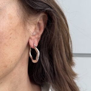 Foto gioiello indossata: orecchini a cerchio ondulato in oro bianco