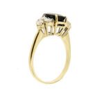 lato di anello oro giallo con zaffiro blu ovale centrale e diamanti ai lati