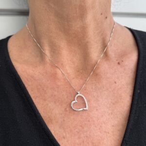 Foto gioiello indossata: collana con ciondolo cuore in oro bianco con diamanti