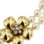 zoom dettaglio diamanti su fiore oro giallo di bracciale doppio filo con perle