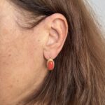 Foto gioiello indossata: orecchini in oro giallo a monachella con corallo