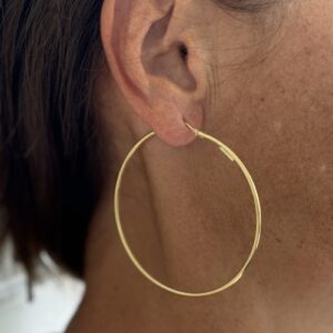 Foto gioiello indossata: orecchini a cerchio in oro giallo