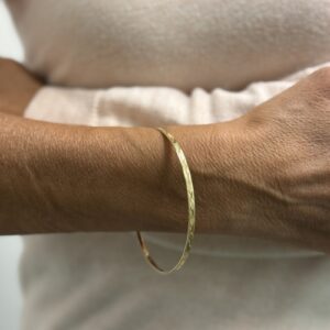 Foto gioiello indossata: bracciale bangle rigido in oro giallo