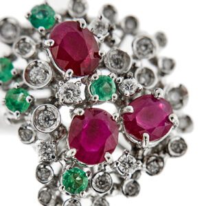 zoom dettaglio diamanti rubini e smeraldi di anello oro bianco