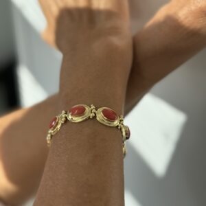 Foto gioiello indossata: bracciale in oro giallo con corallo rosso