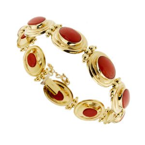 Bracciale a maglia ovale in oro giallo 18kt con 9 coralli rossi, taglio cabochon e chiusura a cassetto e catenina rolò di sicurezza.