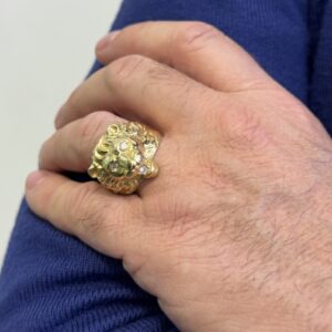 Foto gioiello indossata: anello in oro giallo testa di leone con diamanti
