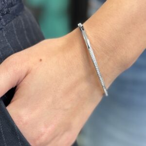 Foto gioiello indossata: bracciale rigido in oro bianco con diamanti bangle