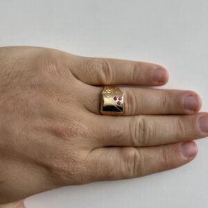 Foto gioiello indossata: anello a scudo da uomo in oro giallo con rubini