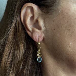 Foto gioiello indossata: orecchini pendenti in oro giallo con topazi