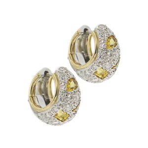 Orecchini a cerchio piccolo bombato in oro giallo e oro bianco 18kt della collezione Schegge con 50 diamanti taglio brillante, totale 1,30 ct e 6 zaffiri gialli a forme geometriche. Brand: Pomellato.
