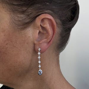 Foto gioiello indossata: orecchini pendenti in oro bianco con diamanti e zaffiri