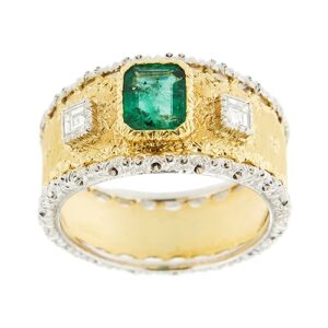 Anello a fascia in oro giallo e oro bianco 18kt con smeraldo rettangolare centrale da 0,70 ct e ai lati 2 diamanti quadrati taglio carré da 0,10 ct cad., colore FG - purezza VVS, ornato con motivi loreali e incisione rigata. Brand: Buccellati.