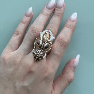Foto gioiello indossata: anello con dragone in oro rosa con diamanti, rubini e smalto nero. Brand: Roberto Coin