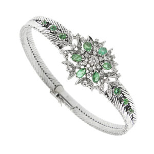 Bracciale in oro bianco 18kt, maglia a spina di pesce e parte centrale a motivo floreale con 12 smeraldi (6 a goccia, 6 rotondi in degradé ai lati). E 43 diamanti: uno centrale taglio brillante da 0,10 ct 42 taglio huit huit da 0,01 ct cad., totale 0,52 ct - colore FG e purezza VS; chiusura a scomparsa con sicura.