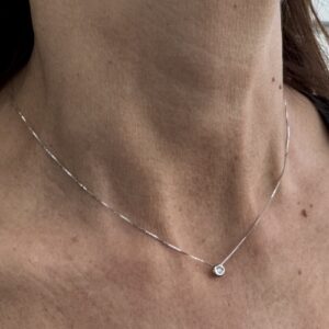 Foto gioiello indossata: collana in oro bianco punto luce con diamante