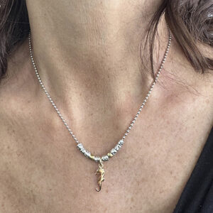 Foto gioiello indossata: collana in argento Dodo maglia pallini con 8 granelli argento e due oro e ciondolo Dodo ippocampo