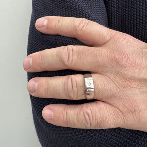 Foto gioiello indossata: anello uomo a scudo in oro bianco con diamantino centrale