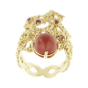 Anello in stile oro giallo grezzo 18kt a forme geometriche traforate con corallo rotondo taglio cabochon e 4 rubini da 0.05 ct cad, totale 0.20 ct.
