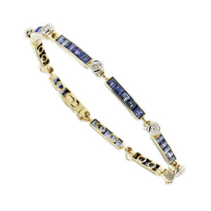 Bracciale Art Deco a segmenti in oro giallo e bianco 18kt con 45 zaffiri taglio carré alternati e 9 diamanti taglio vecchio europeo da 0.10 ct cad, totale 0.90 ct, colore FG - purezza VS; incastonati a notte, chiusura a scomparsa e catena maglia forzatina come sicura.