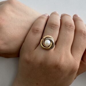 Foto gioiello indossata: anello in tre ori (oro bianco, oro giallo e oro rosa) con perla bianca centrale