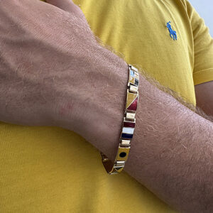 Foto gioiello indossata: bracciale in oro giallo con bandierine nautiche smaltate da uomo, brand: Arcadia
