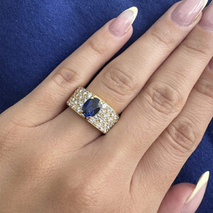 Foto gioiello indossata: anello a fascia in oro giallo con diamanti e zaffiro centrale