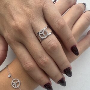Foto gioiello indossata: anello a fascia in oro bianco 18kt con simbolo pace con diamanti
